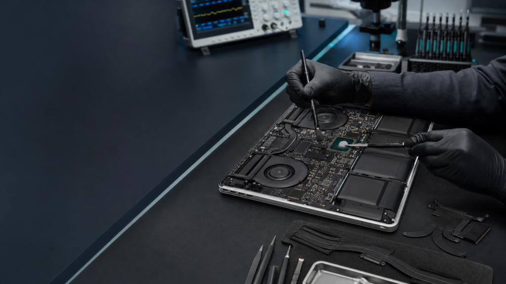 Técnico realizando limpieza interna y mantenimiento térmico profesional en un MacBook Pro